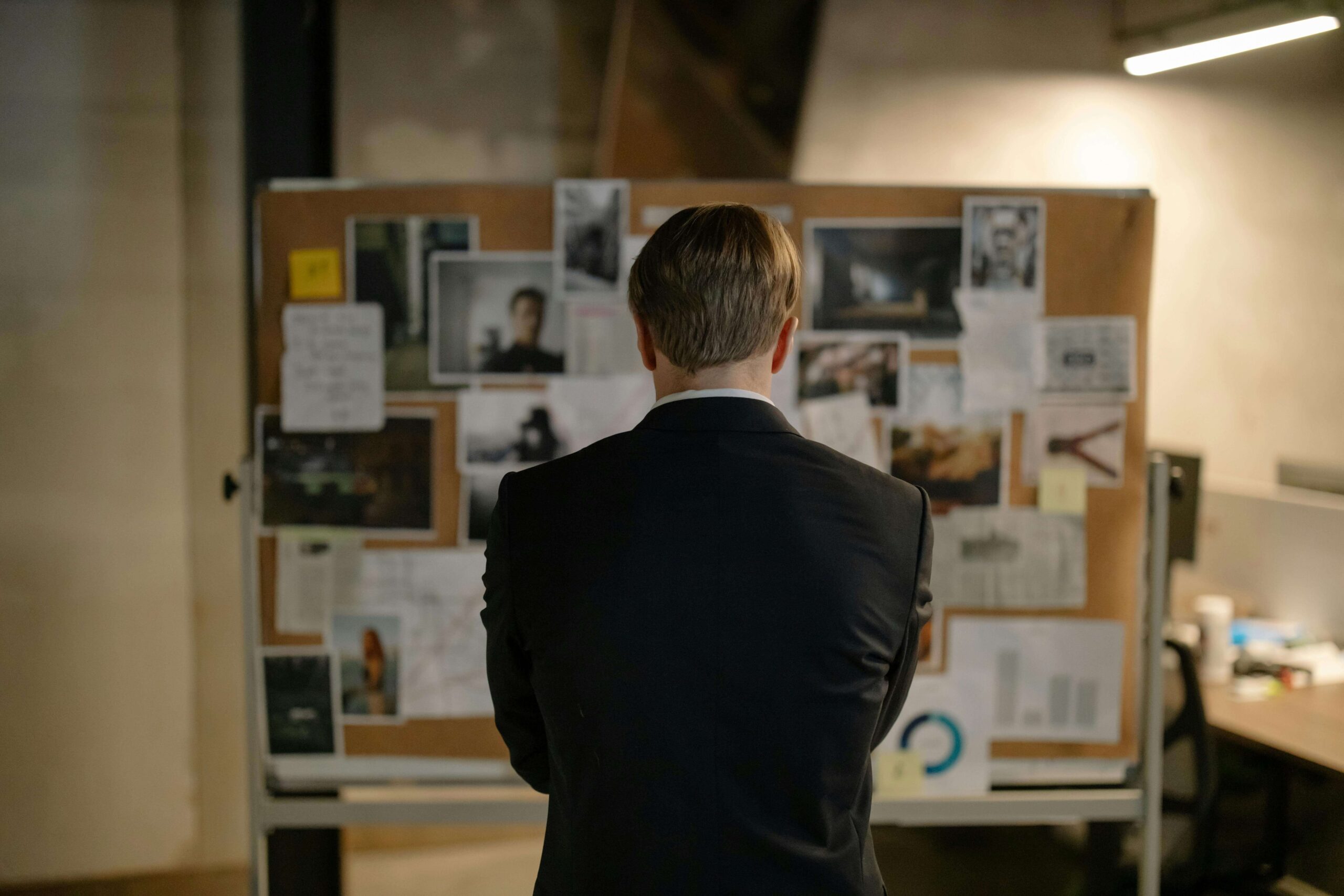 detective looking at leads on his detective board