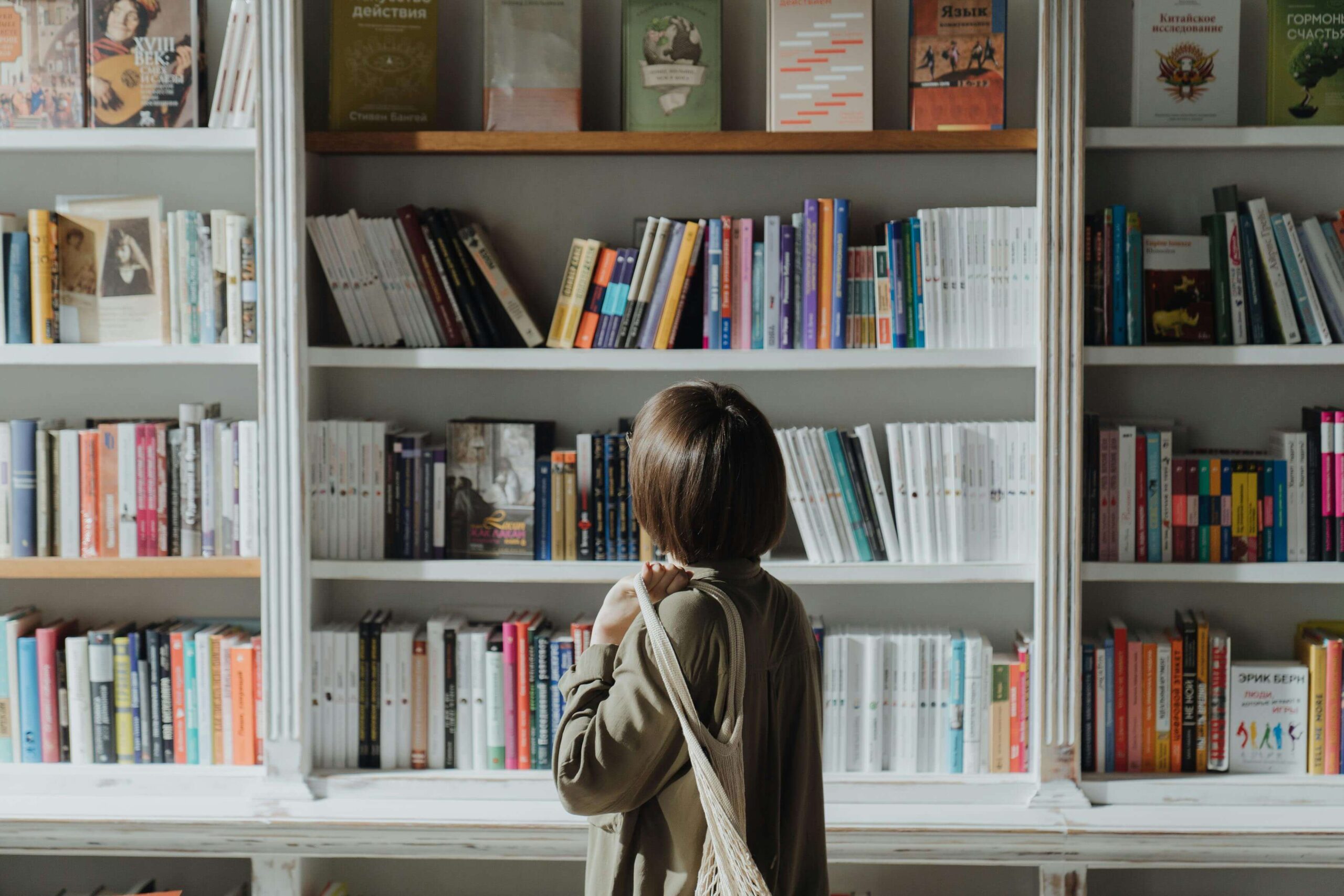 Woman looking for a book from a bookshelf in a bookstore