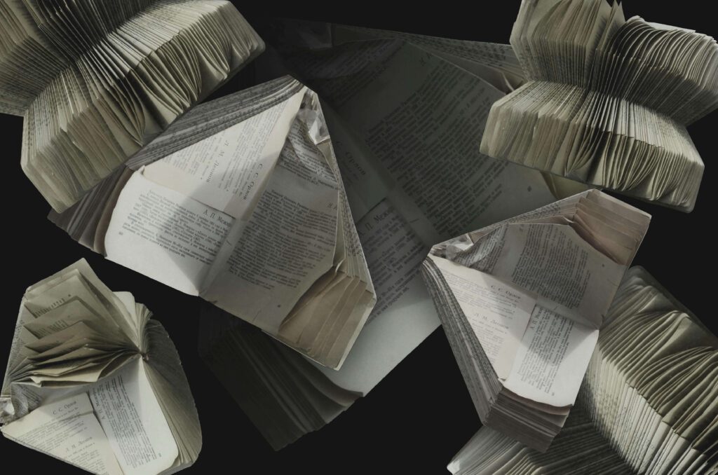 folded book pages strewn around