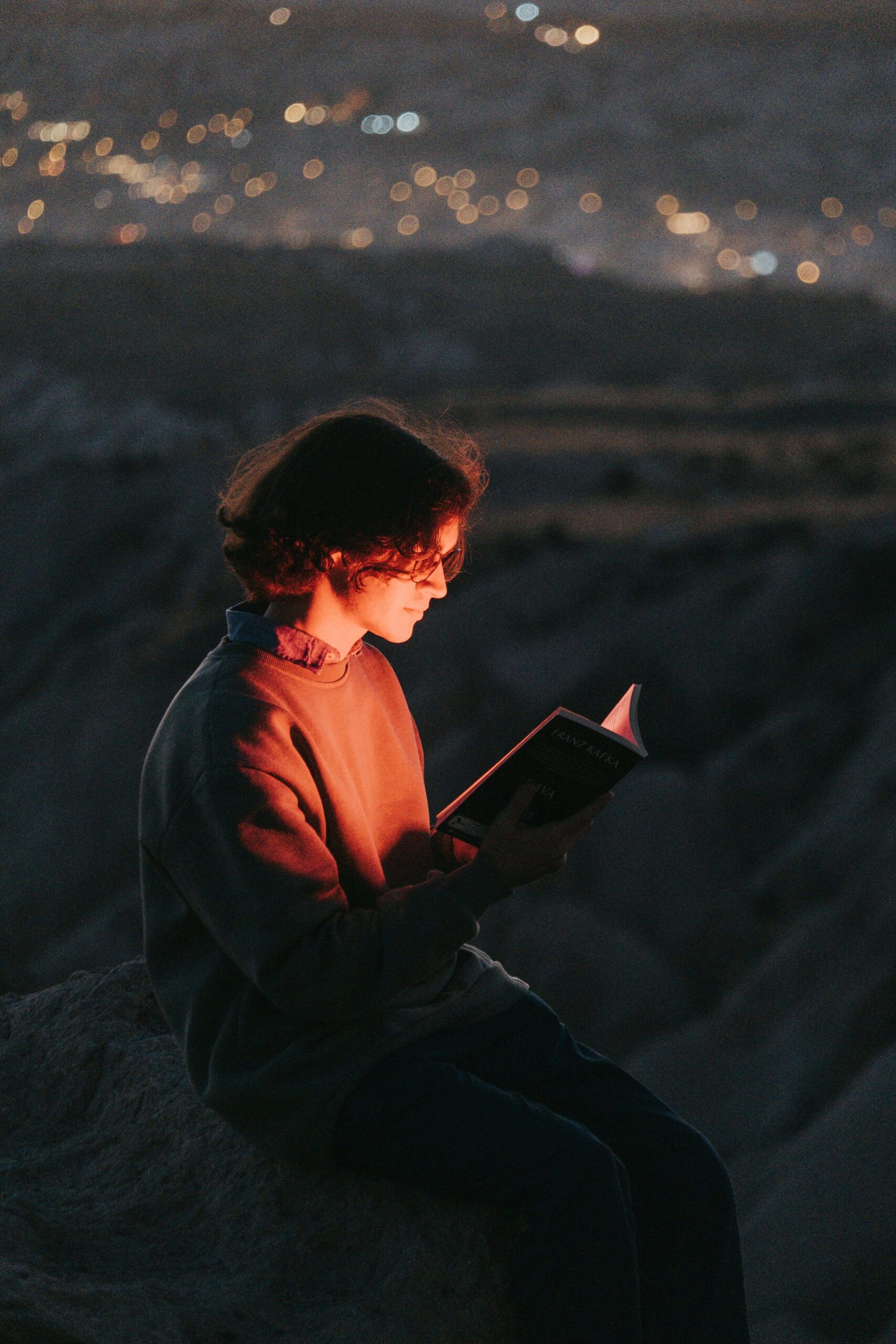 man reading a book on a mountain