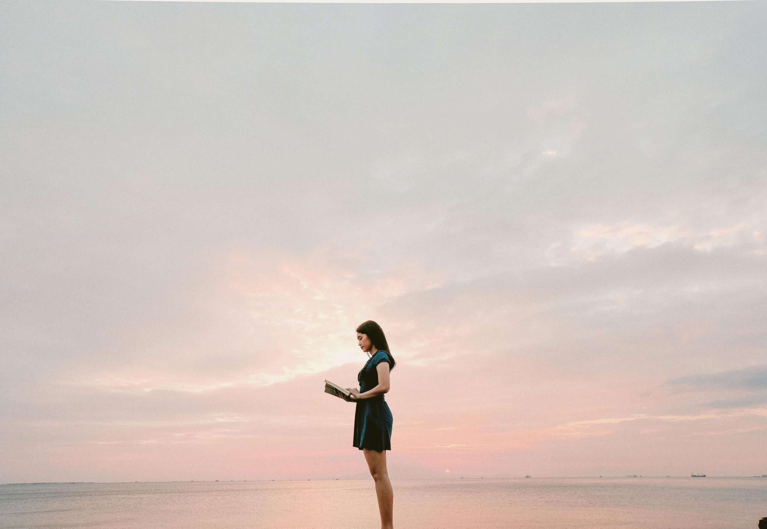 woman reading a book by the sea